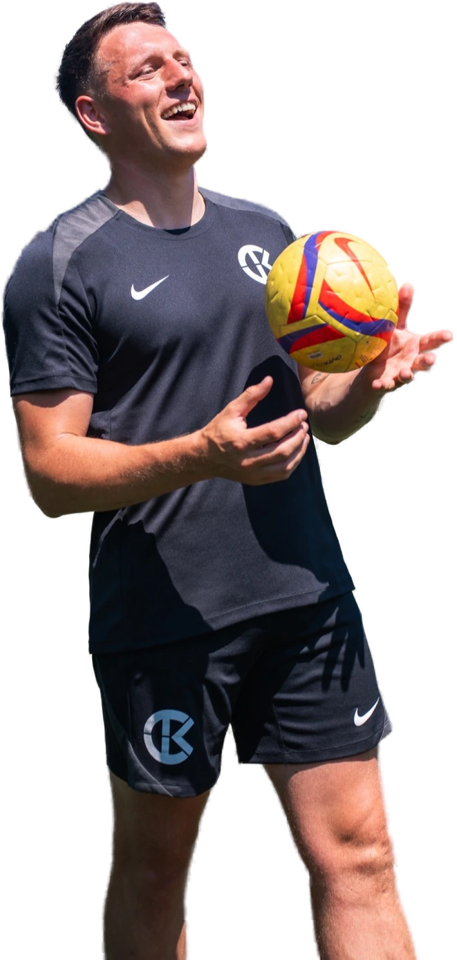 Coach Kier on the pitch, ball in hand